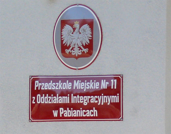Zdjęcie przedstawia godło Polski wraz z tabliczką, na której
                napisane jest: Przedszkole Miejskie Nr 11 z Oddziałami Integracyjnymi w Pabianicach.